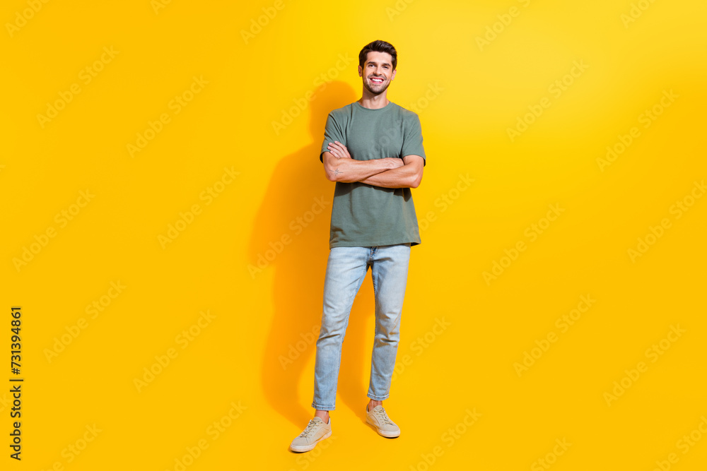 Wall mural Full length photo of cool confident guy wear khaki t-shirt arms crossed smiling isolated yellow color background