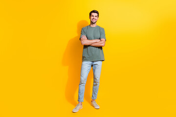 Fototapeta na wymiar Full length photo of cool confident guy wear khaki t-shirt arms crossed smiling isolated yellow color background