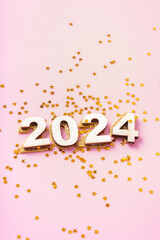 Fototapeta na wymiar Numbers 2024 and stars on a pink background. Happy new year concept