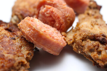 pieces of sausage with chicken wings. details of pork and chicken. meal details. meats with selective focus.