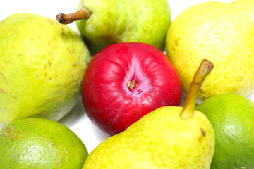 fruits and vegetables. red plum amid lemons, guavas and pears. red fruit among the green fruits. set of green and red fruits.