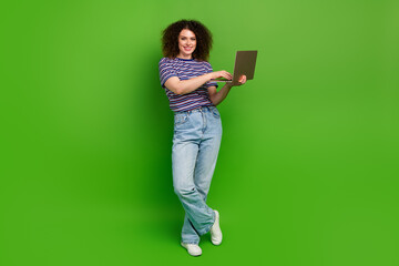 Full body portrait of pretty positive lady hold netbook coworking empty space isolated on green color background