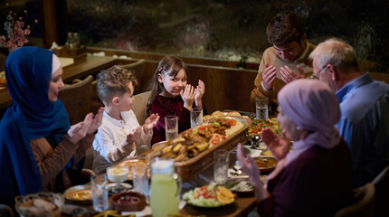 Fototapeta na wymiar In a modern restaurant setting, a European Islamic family comes together for iftar during Ramadan, engaging in prayer before the meal, uniting tradition and contemporary practices in a celebration of