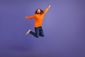 Full body length photo of energetic man raised hands up jumping when realize he done all his exams isolated on violet color background