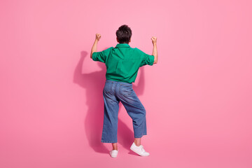 Full size photo of pretty retired female raise fists celebrate winning wear trendy green outfit isolated on pink color background