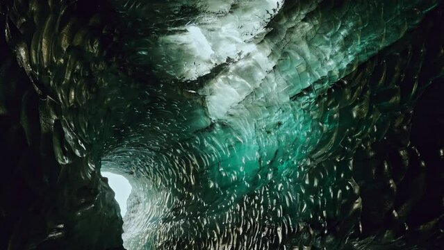 Static shot inside the Katla ice caves near Vik, Southern Iceland. View of the majestic frozen caves.  
Vibrant turquoise ice formation.