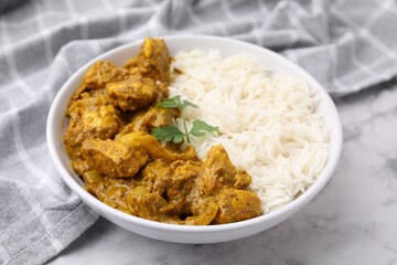 Delicious chicken curry with rice on white marble table, closeup
