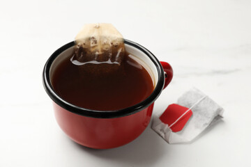 Tea bag in cup on white table, closeup
