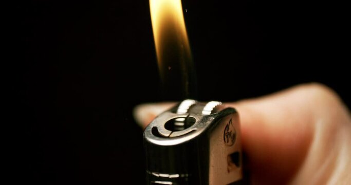 enchanting display of sparks and flames as a hand flicks a lighter in mesmerizing slow motion