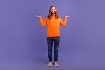 Full body length photo of young handsome blond guy wear orange sweater promoting two best products on market over violet color background