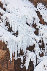 Fototapeta na wymiar A waterfall frozen in the cold winter. mountain cliffs