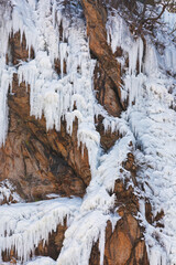 A waterfall frozen in the cold winter. mountain cliffs