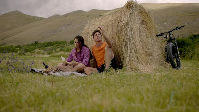 two lovers having a picnic in the fields near to a hay bale in campo imperatore abruzzo italy