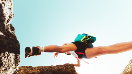Low angle close up young caucasian sporty woman training steps on rock climb outdoors in sunny hot weather alone. Inspirational active strong woman sports activities outdoors - Powered by Adobe