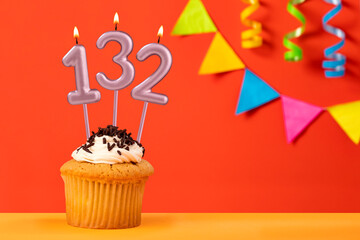 Birthday cupcake with number 132 candle - Sparkling orange background with bunting