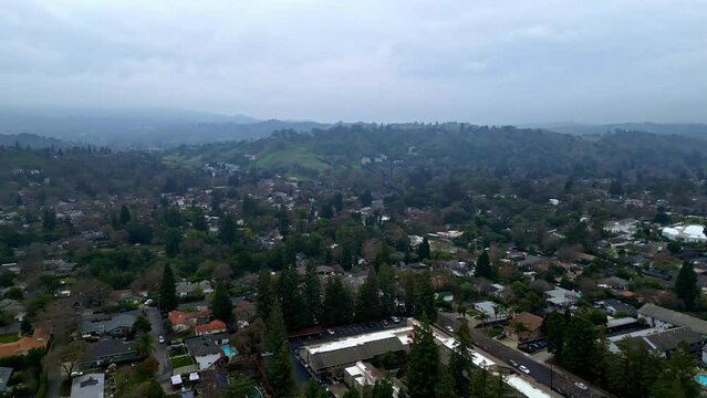 Aerial drone forward moving shot over posh residential bungalows in Walnut Creek, California, USA on a cloudy day.
