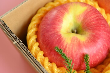 beautiful apple in the box on pink background, healthy fruit