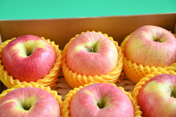 beautiful pink apple in the box on green background, healthy fruit