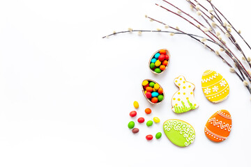 Happy Easter background with eggs and bunny cookies with spring branch, top view