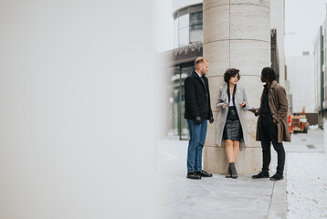 Three modern business associates engaged in a casual discussion outdoors, fostering collaboration...