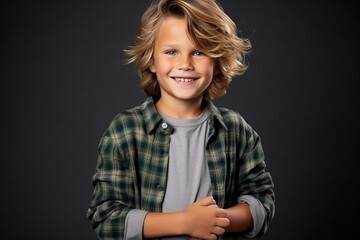 Portrait of a cute little boy with blond hair over dark background