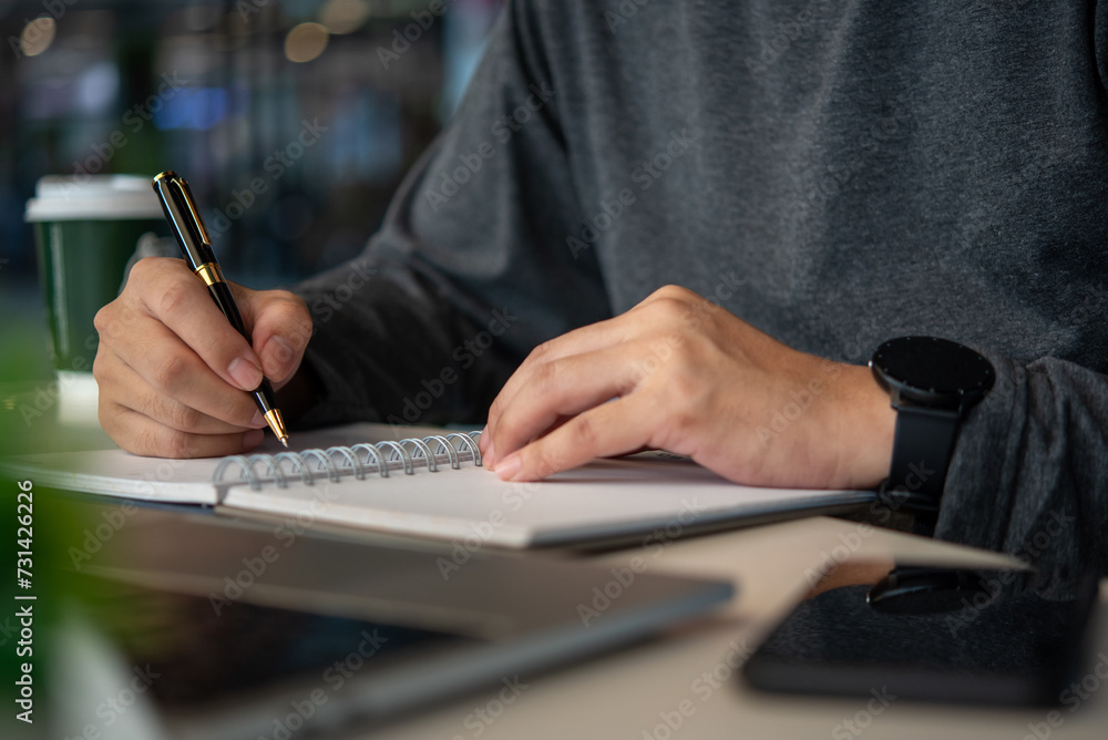Poster man hands with pen writing on notebook at table.learning, education and work.writes goals, plans, ma
