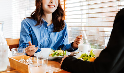 カフェで楽しそうにランチを食べる2人のビジネスウーマン
