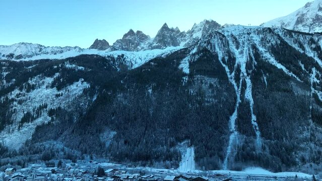 Aerial Tilt down from dramatic Alps mountains to reveal the ski resort and town of Chamonix, France 