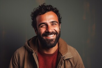 Portrait of a handsome young man smiling at the camera against a dark background