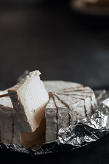 goat cheese cake divided into triangular portions on aluminum or metal foil