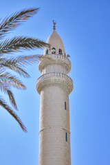 Obraz premium Minaret of a Muslim mosque over the blue sky, Aqaba, Jordan.