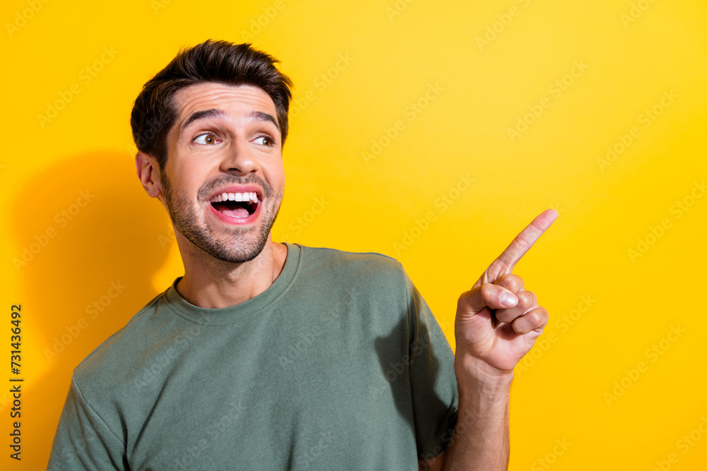 Poster portrait of overjoyed crazy guy with stubble wear stylish t-shirt look directing at promo empty spac