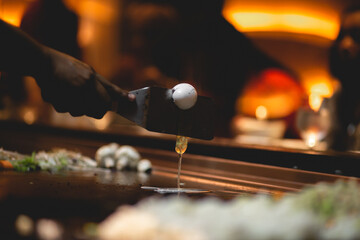 In Teppanyaki, Japanese cuisine style,c hef might juggle utensils, flip a shrimp tail into their shirt pocket, catch an egg in their hat, toss an egg up in the air and split it with a spatula