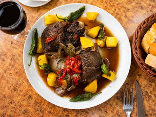 Appetizing fried pork in red wine with potatoes and stewed vegetables