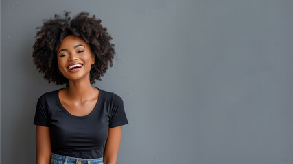 Afro young woman wear black t-shirt smile isolated on grey background - obrazy, fototapety, plakaty
