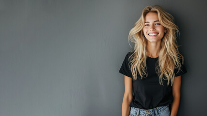 Blonde young woman wear black t-shirt smile isolated on grey background - obrazy, fototapety, plakaty