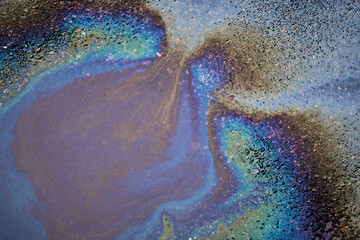 Oil stain on Asphalt in a puddle, color Gasoline fuel spots on Asphalt Road as Texture or Background
