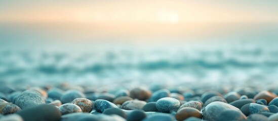 A beautiful scene of azure rocks piled on a calm beach with the electric blue ocean in the background, merging with the cloud-dotted horizon.