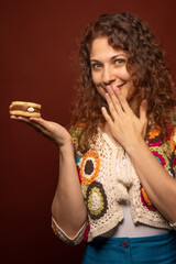 Smiling Latina Holds a Tempting dulce de leche pastry on hand. Vertical.