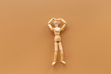 Wooden figurine of a man head wrapped in bandage - concussion or head injury