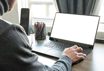 Hombre profesional trabajando en la computadora portátil desde su hogar.
