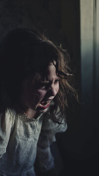 cinematic image of a scared little girl crying in the dark room. The image is minimal and has a powerful emotion.