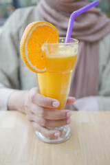 women holding a glass of orange juice 