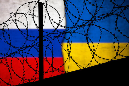 Flaggen von Russland und Ukraine hinter dem Stacheldraht