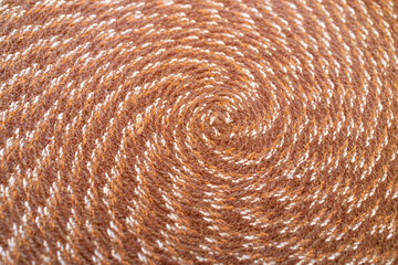 Macro abstract texture background of a circular pattern woven fabric placemat in colors of brown and white

