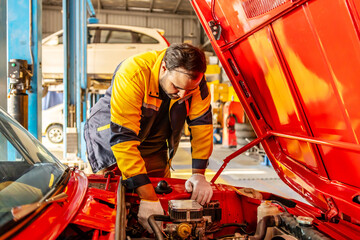 Mechanic Asian man examining tuning fixing repairing car engine automobile vehicle parts using...