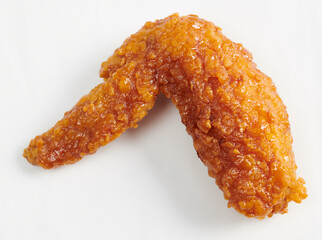 Hot crispy korean fried chicken wing on a fork isolated on white background