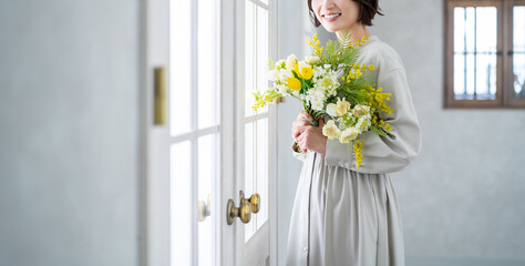 室内で花束を持つ日本人女性 - obrazy, fototapety, plakaty