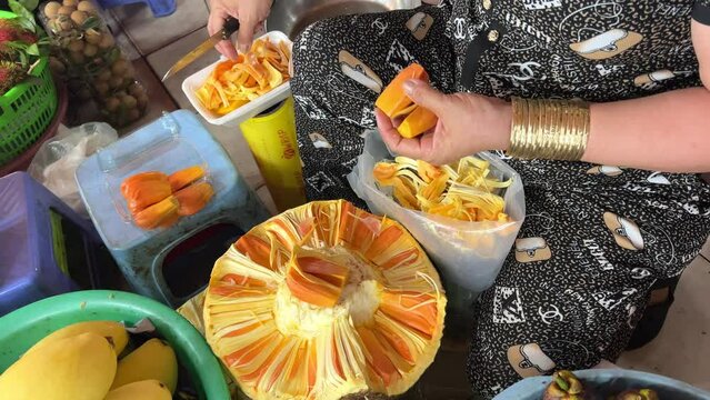 cutting section out of a breadfruit Artocarpus altilis At the market, traders clear Place in plastic container for sale