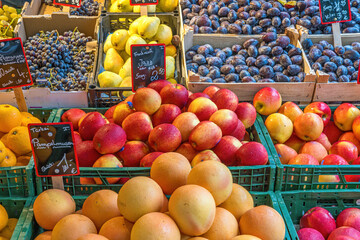 Oranges, apples and plums for sale at a market